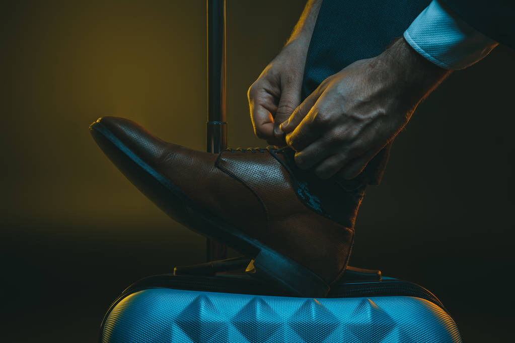 şık adam bavula ayakkabı bağcığı bağlama - Fotoğraf, Görsel