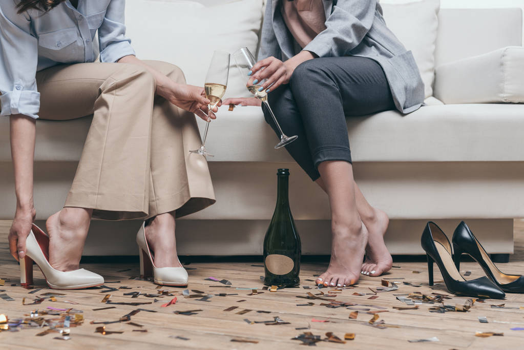 women drinking champagne while resting on sofa - Photo, Image