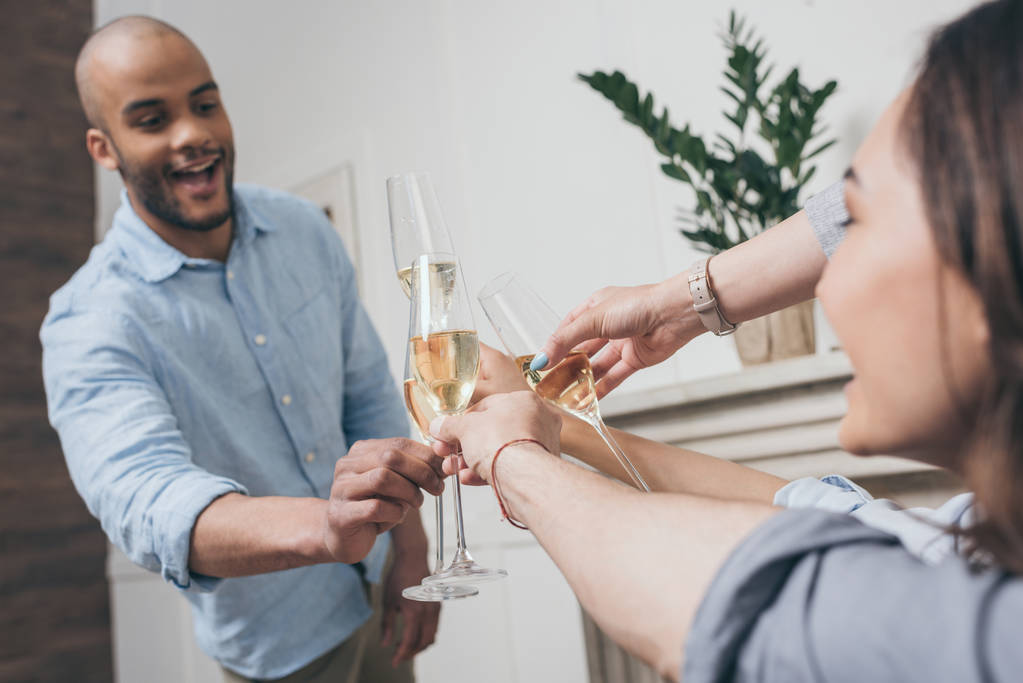 vrienden rammelende met champagneglazen thuis - Foto, afbeelding