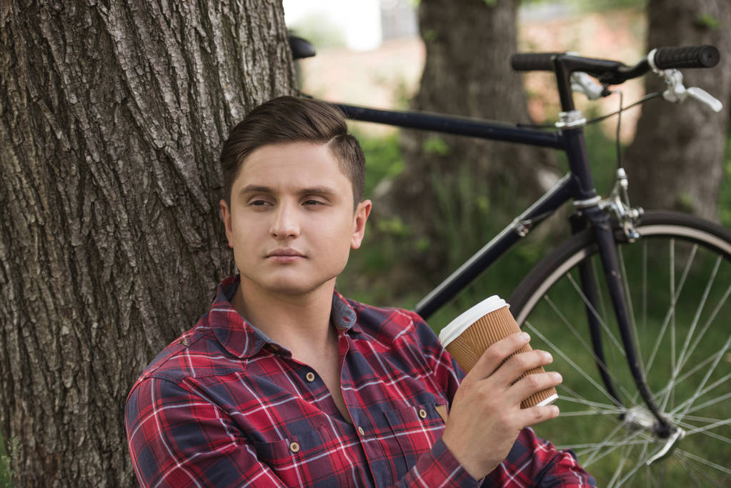 Hombre relajante con taza de café en el parque
 - Foto, Imagen