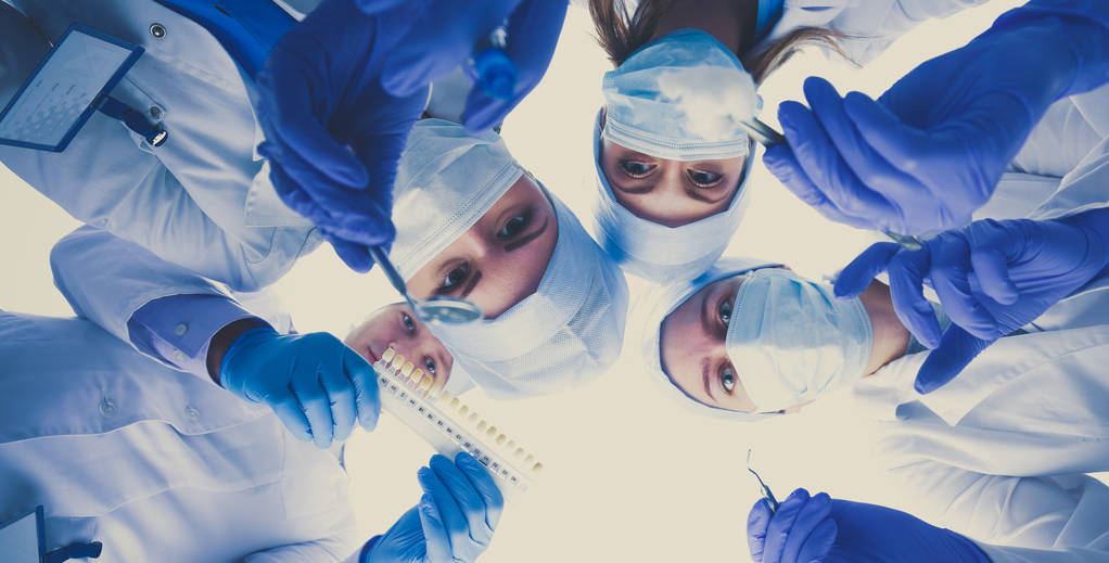 Pohled ze spodu maskované lékařů při pohledu na pacienta během vyšetření . - Fotografie, Obrázek
