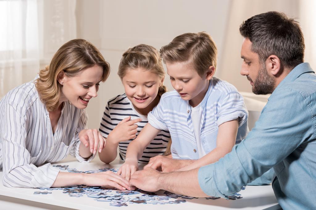 Família jogando com quebra-cabeça
  - Foto, Imagem