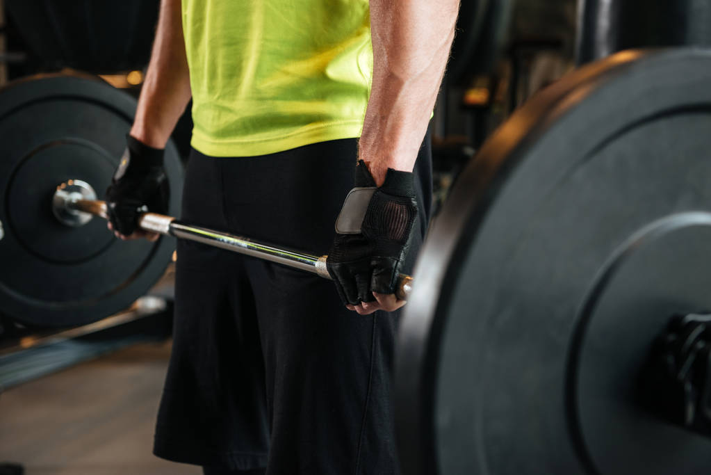 Imagen recortada de un deportista sosteniendo pesadas pesas
 - Foto, Imagen