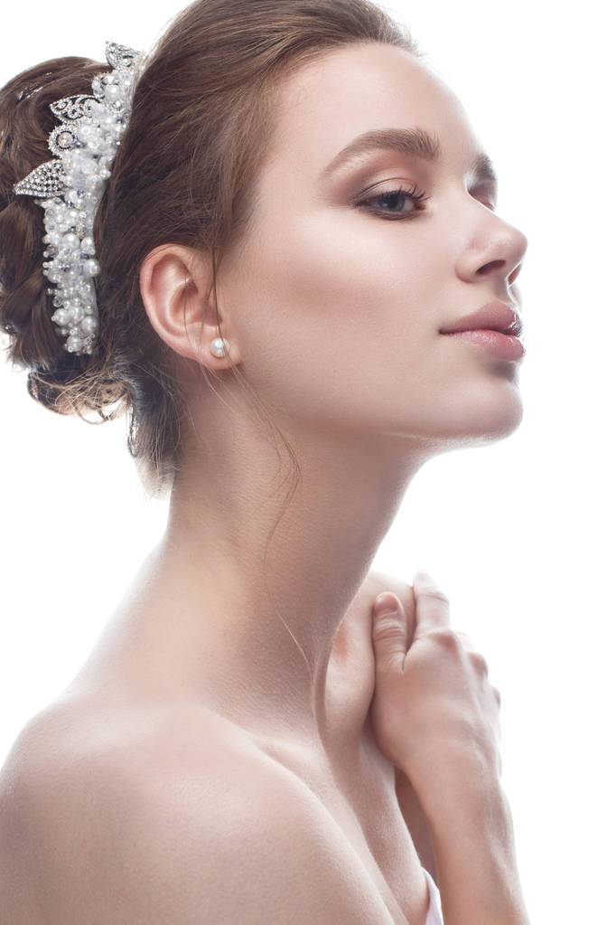 A young girl in a gentle wedding image with a diadem on her head. Beautiful model in the image of the bride on a white isolated background with nude makeup. Pure shining skin.  - Photo, Image