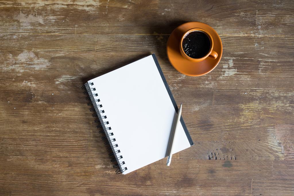 κάτοψη του σημειωματάριο με μολύβι και Καφές Κύπελλο στην ξύλινη επιτραπέζια  - Φωτογραφία, εικόνα