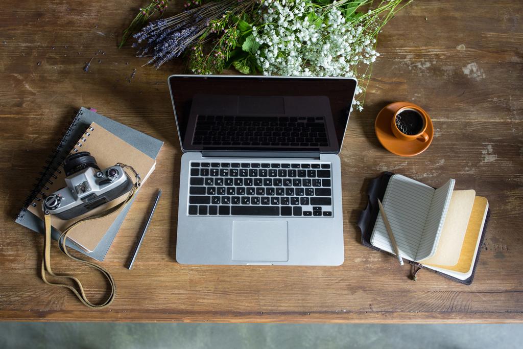верхний вид ноутбука, дневники, винтажная фотокамера и чашка кофе на деревянном столе
 - Фото, изображение