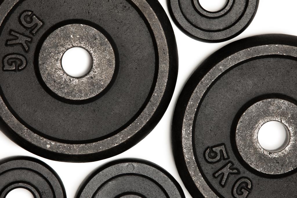 Visão de close-up de diferentes placas de peso para treinamento de peso isolado em branco
 - Foto, Imagem