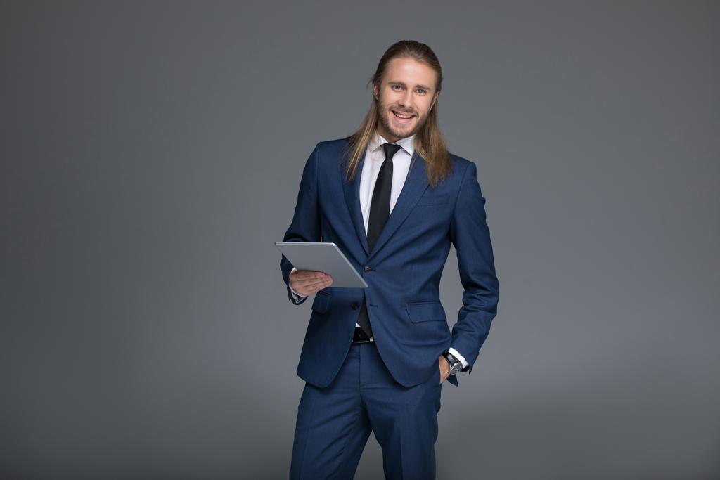 Hombre de negocios sonriente sosteniendo tableta digital
 - Foto, imagen