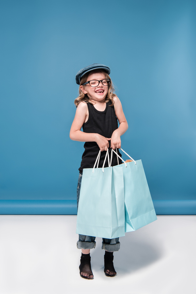 weinig meisje bedrijf shopping tassen - Foto, afbeelding