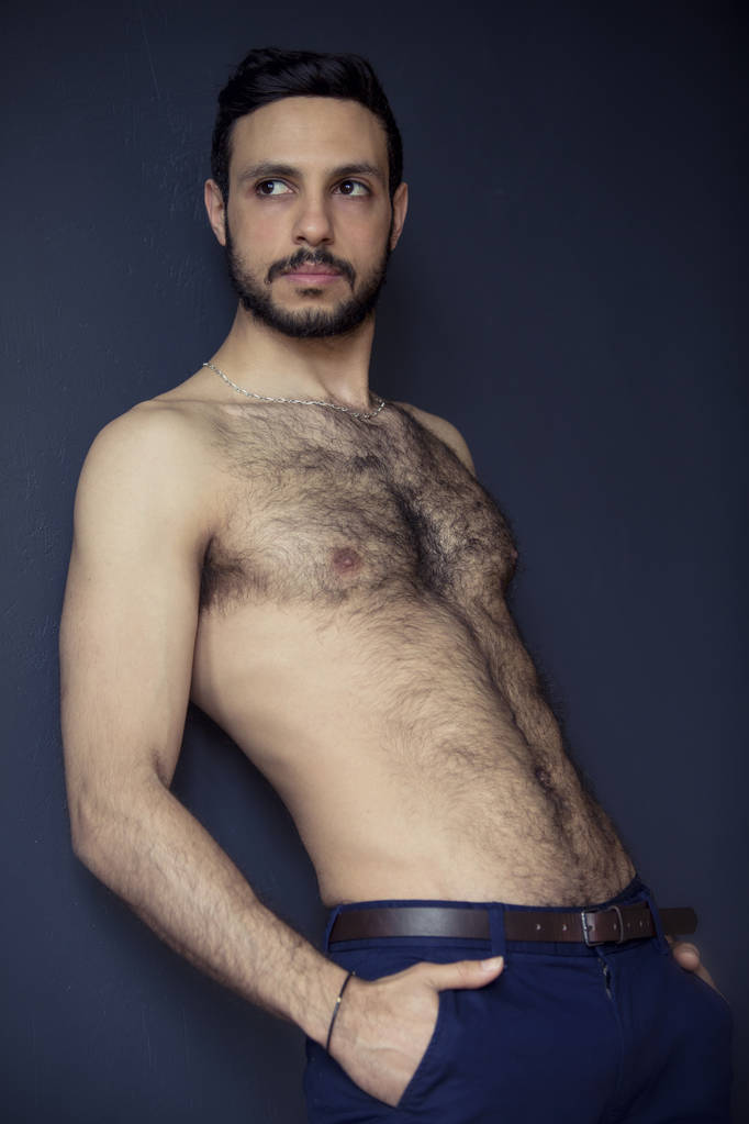 shirtless harige man leunend tegen muur - Foto, afbeelding