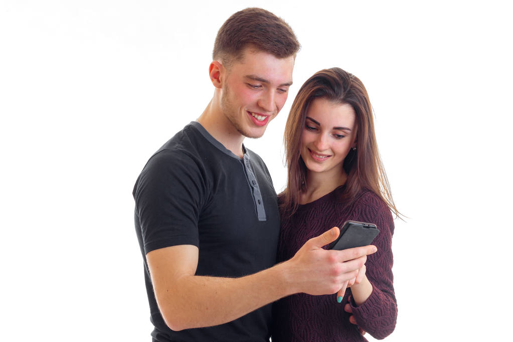 hermosa pareja amorosa viendo una foto en su teléfono y sonriendo aislado sobre fondo blanco
 - Foto, imagen