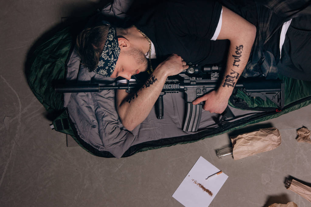 El gángster duerme con rifle. Concepto guerra de pandillas
. - Foto, imagen
