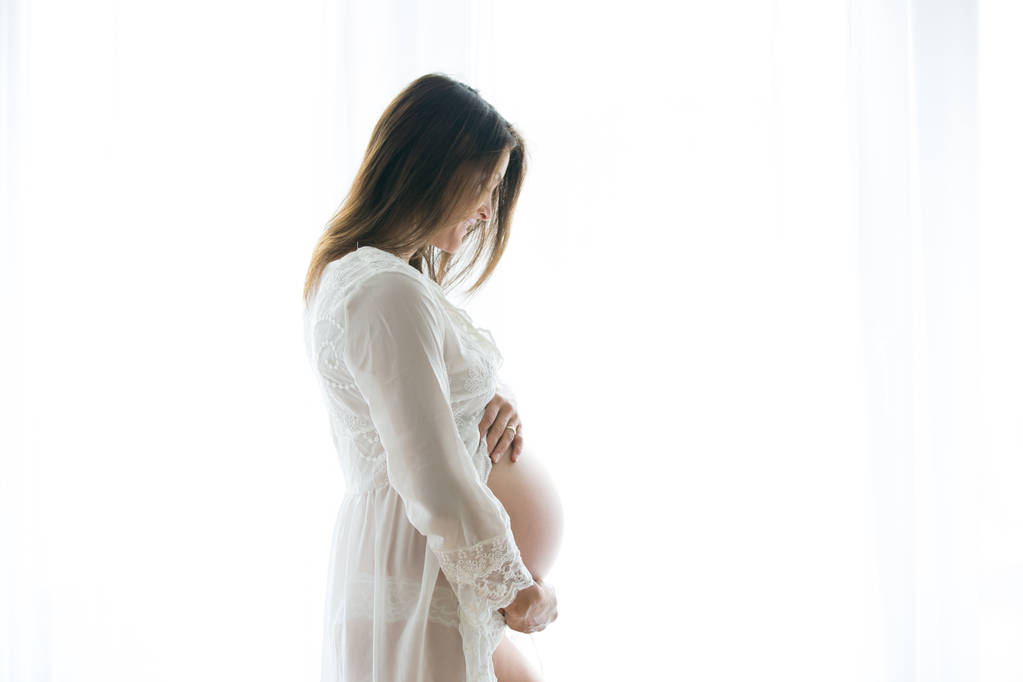 Πορτρέτο του νεαρή έγκυο γυναίκα ελκυστική, στο πλευρό της τη νίκη - Φωτογραφία, εικόνα