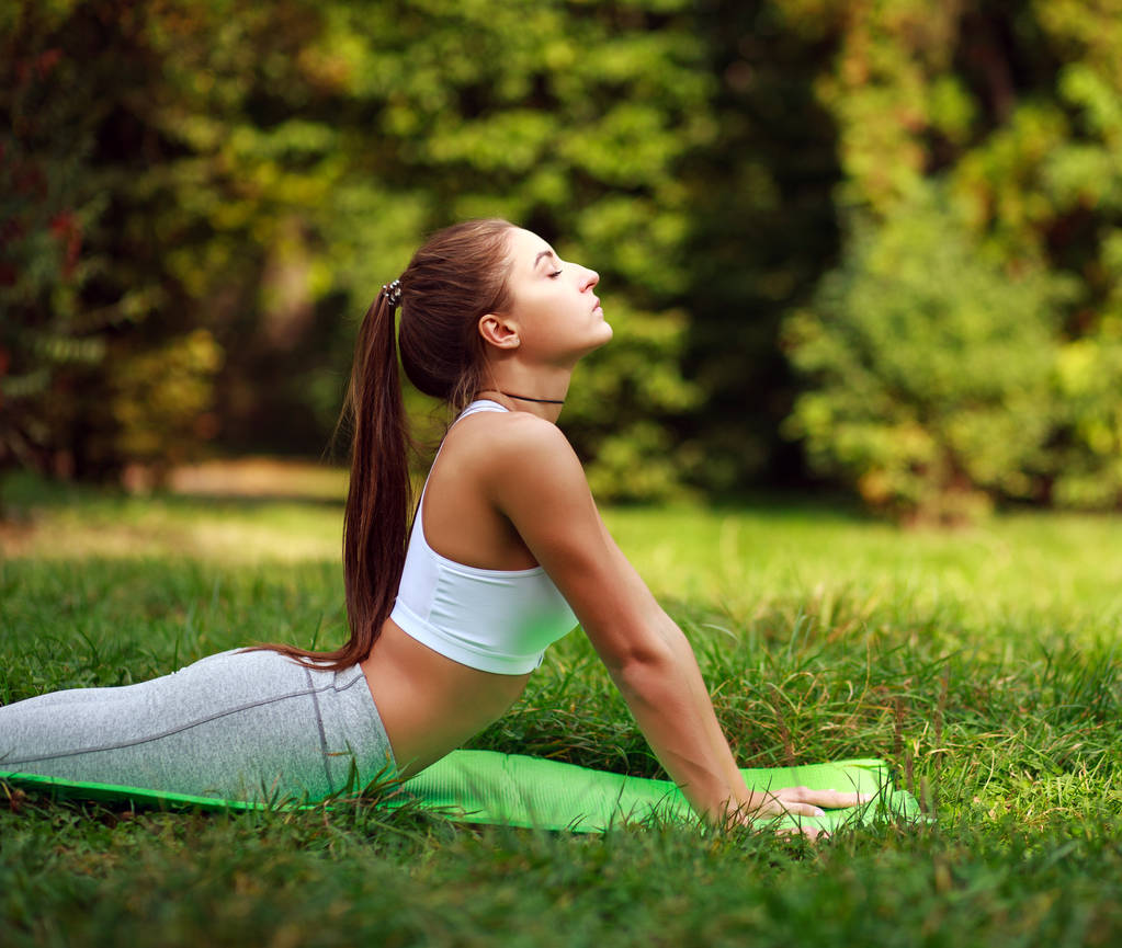 Kobieta robi ćwiczenia fitness w lato park, treningu na zewnątrz - Zdjęcie, obraz