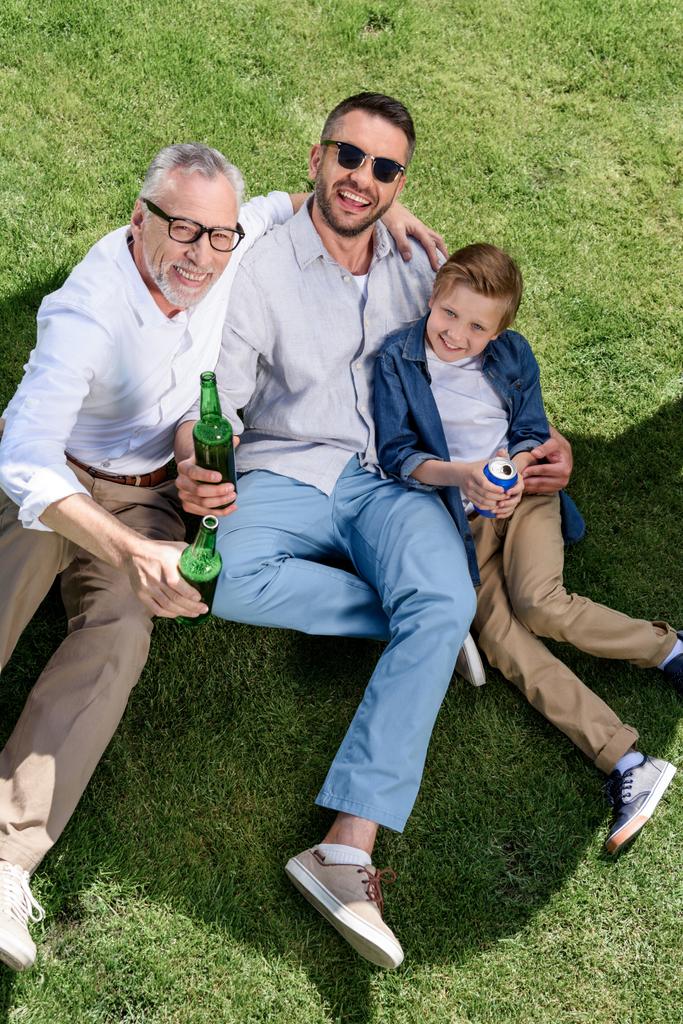 nonno, padre e figlio che si abbracciano sull'erba
 - Foto, immagini