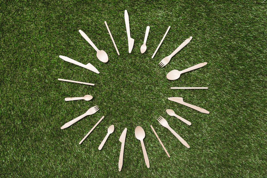 colheres de madeira com garfos e facas na grama
 - Foto, Imagem