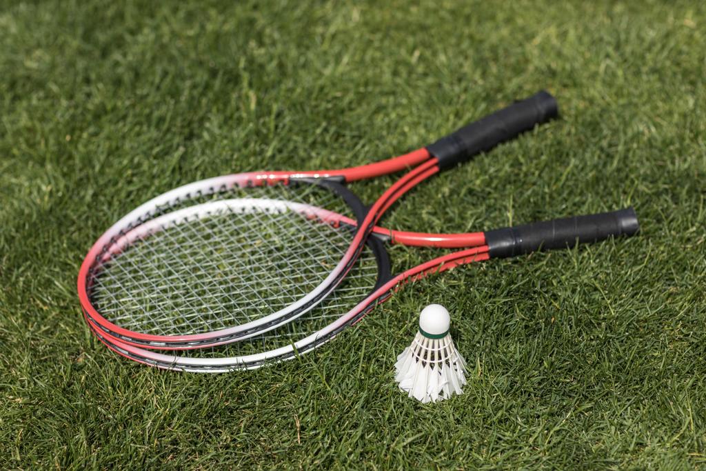 badminton rackets with shuttlecock on grass - Photo, Image