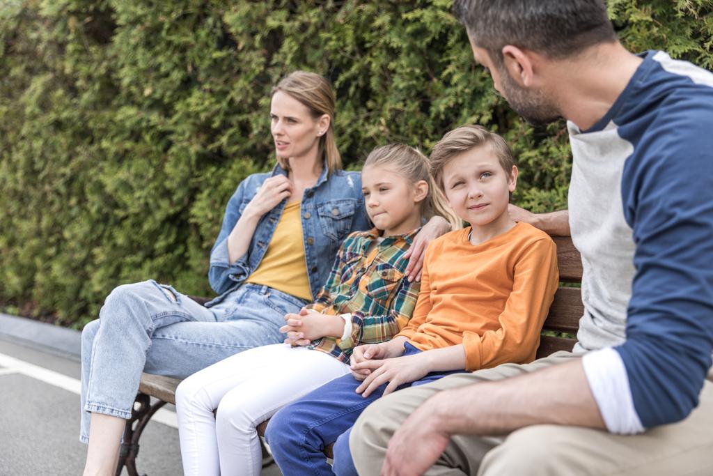 familia hablando mientras está sentado en el banco en el parque
 - Foto, imagen