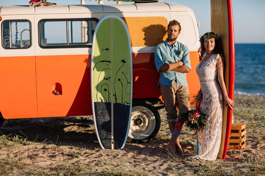 Felice coppia di surfisti in piedi con tavole da surf sulla spiaggia di sabbia
 - Foto, immagini