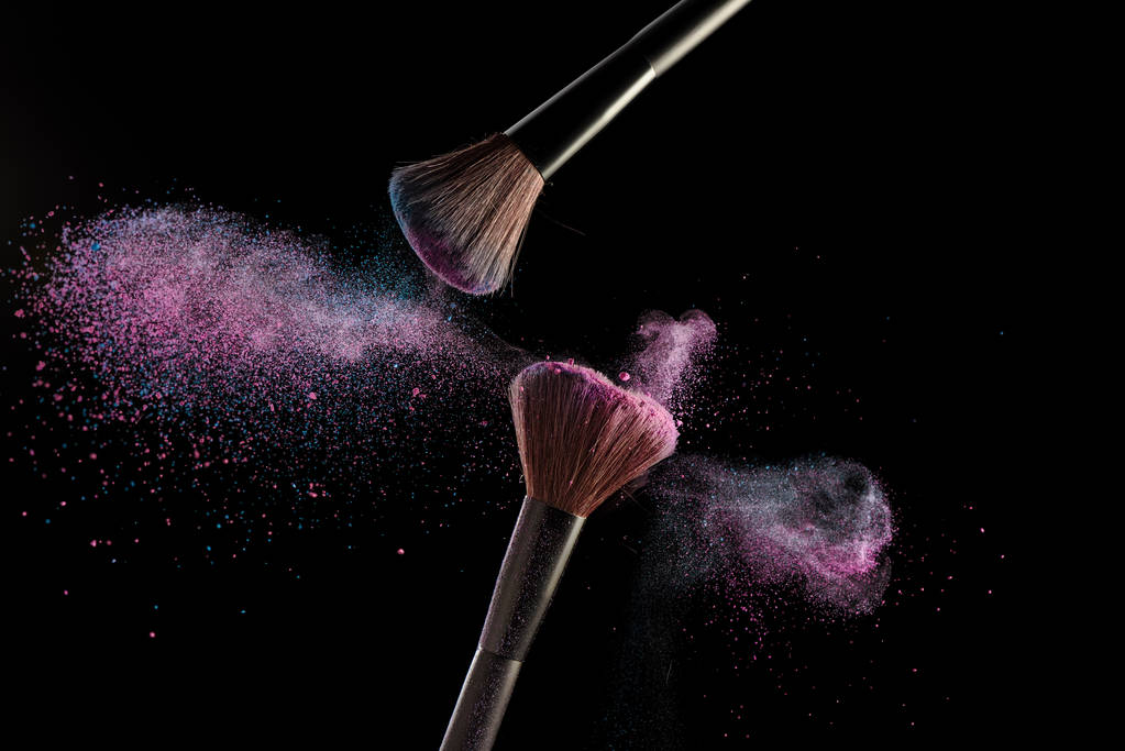 Štětce na make-up s růžový a modrý prášek výbuchu na černém bac - Fotografie, Obrázek