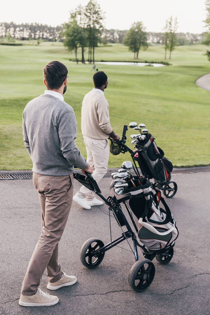 Erkekler golf kulüpleri torbalarda ile  - Fotoğraf, Görsel