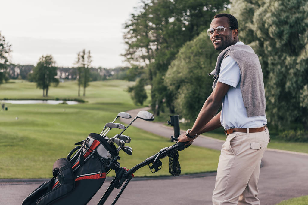 Człowiek z klubów golfowych w torbie  - Zdjęcie, obraz