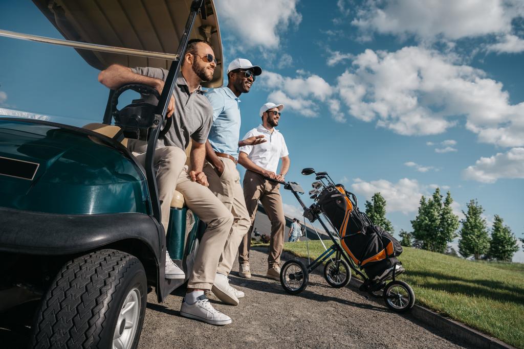 чоловіки, що стоять біля кошика для гольфу
 - Фото, зображення