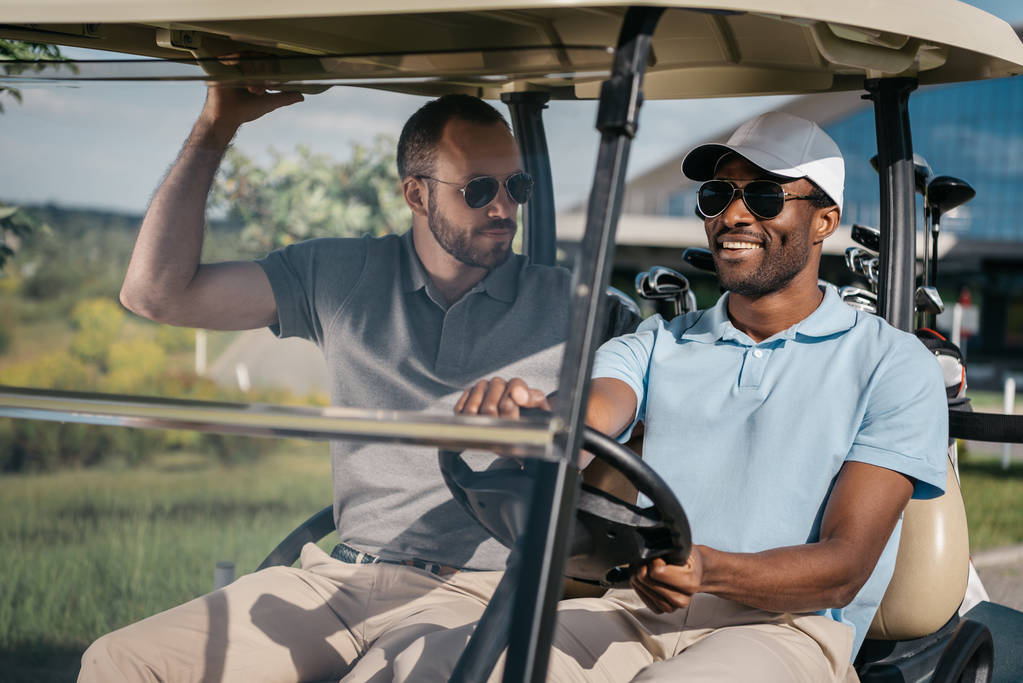 miehet ratsastus golf cart
 - Valokuva, kuva