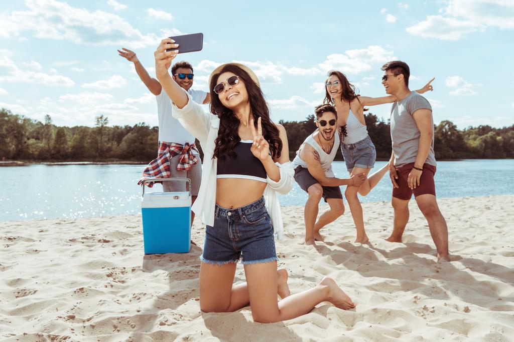 Ystävät ottavat selfie rannalla
 - Valokuva, kuva