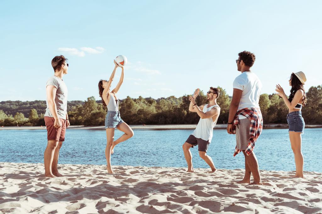 ystävät pelaavat lentopalloa hiekkarannalla
 - Valokuva, kuva