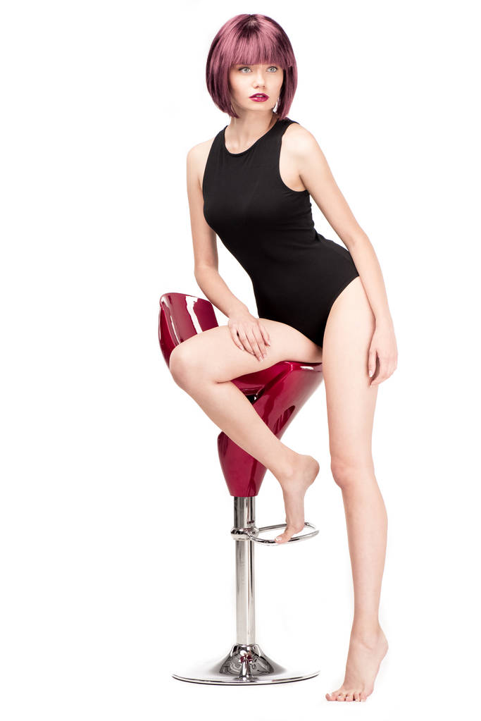 nainen trikoossa poseeraa tuolilla
 - Valokuva, kuva