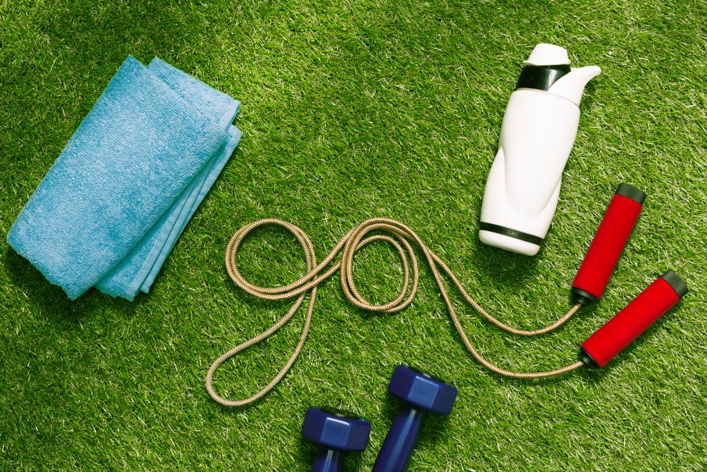 ručníky a láhev s švihadlo na trávě - Fotografie, Obrázek
