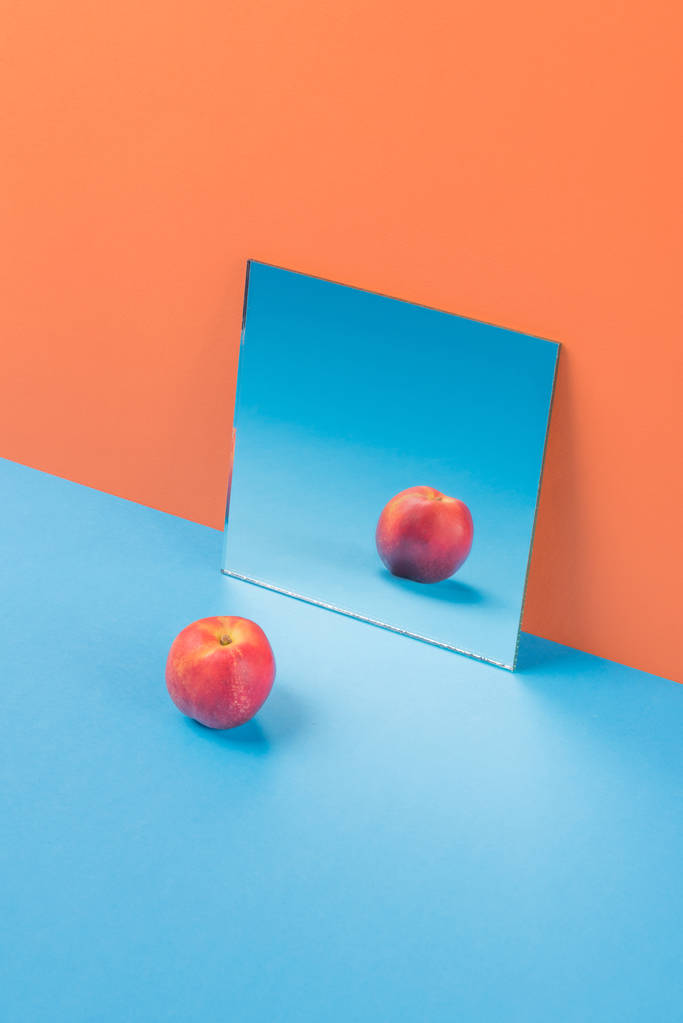 Manzana sobre mesa azul aislada sobre fondo naranja
 - Foto, Imagen