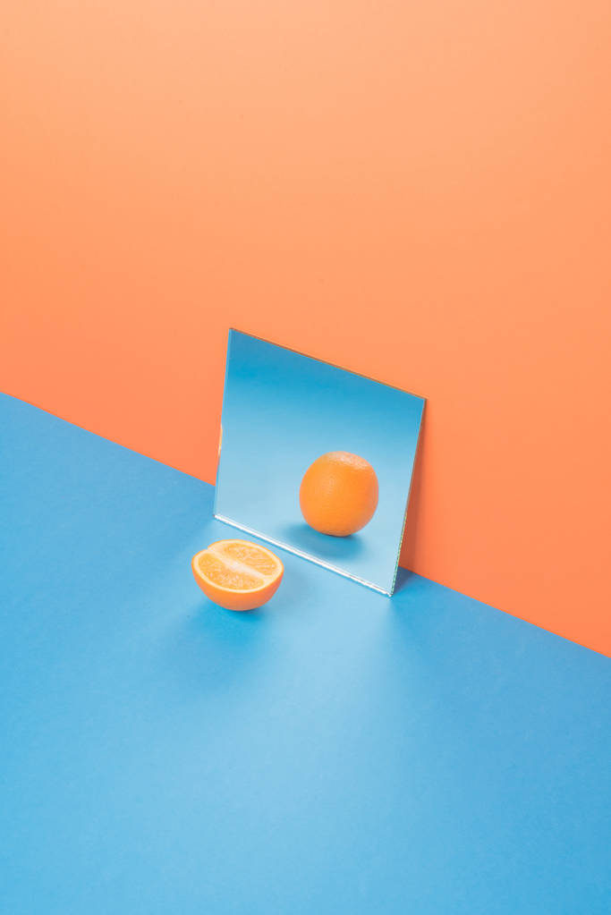 Laranja sobre mesa azul isolado sobre fundo laranja
 - Foto, Imagem