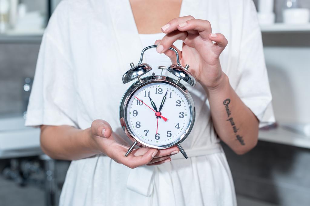 Mujer sosteniendo reloj
  - Foto, Imagen