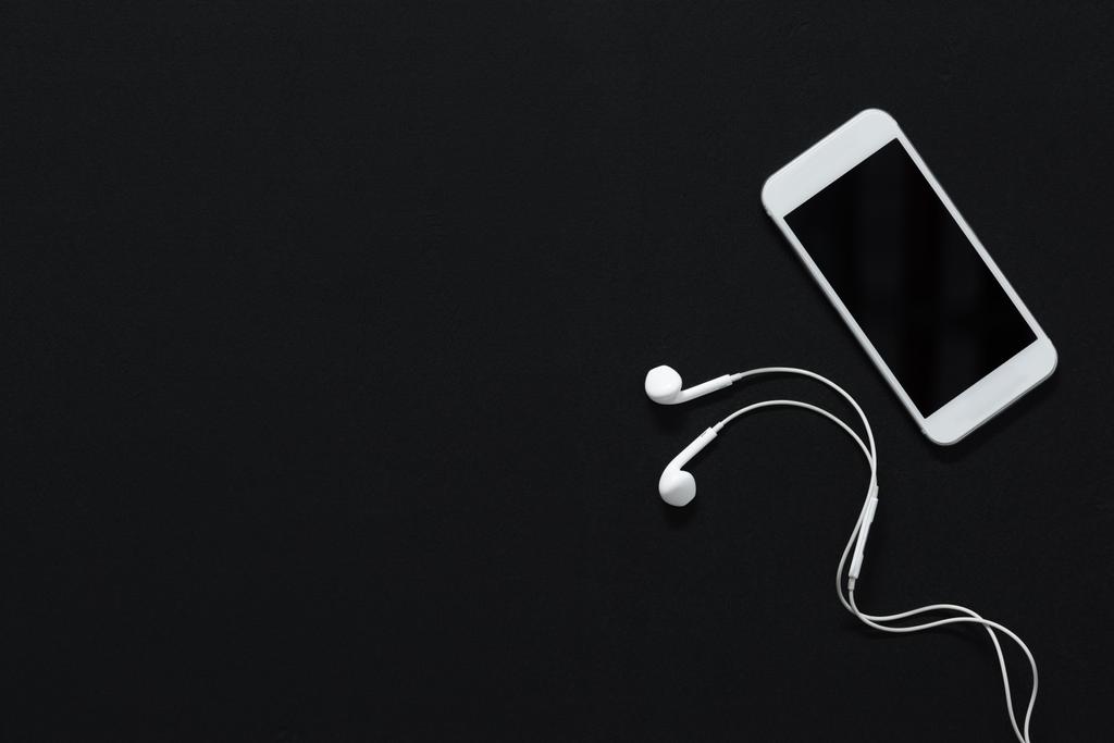 smartphone com tela em branco e fones de ouvido
 - Foto, Imagem
