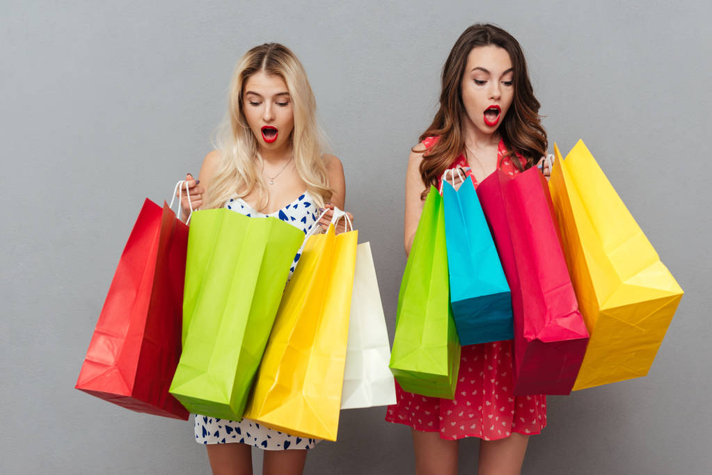 Shocked young two ladies with shopping bags - Photo, Image