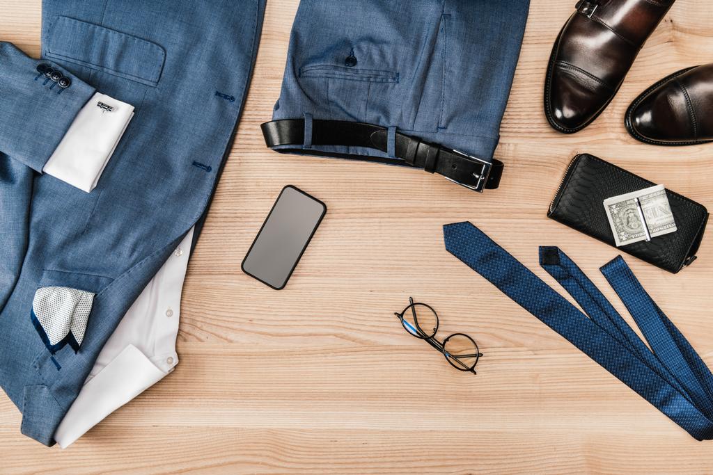 Anzug und Accessoires mit Smartphone auf der Tischplatte - Foto, Bild