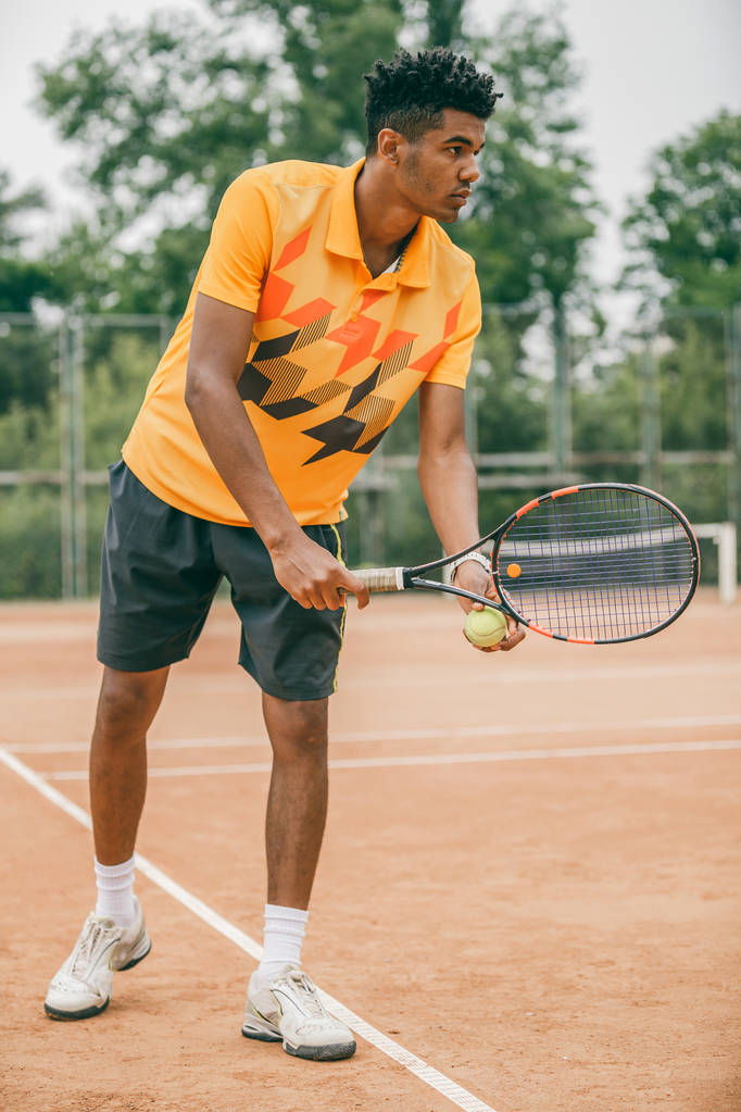 Junge Tennisspielerin mit Schläger bereit, einen Tennisball zu servieren. - Foto, Bild