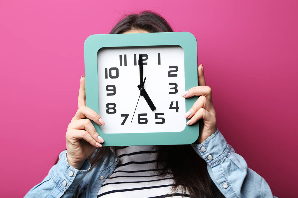 woman holding clock in front of face - Photo, Image