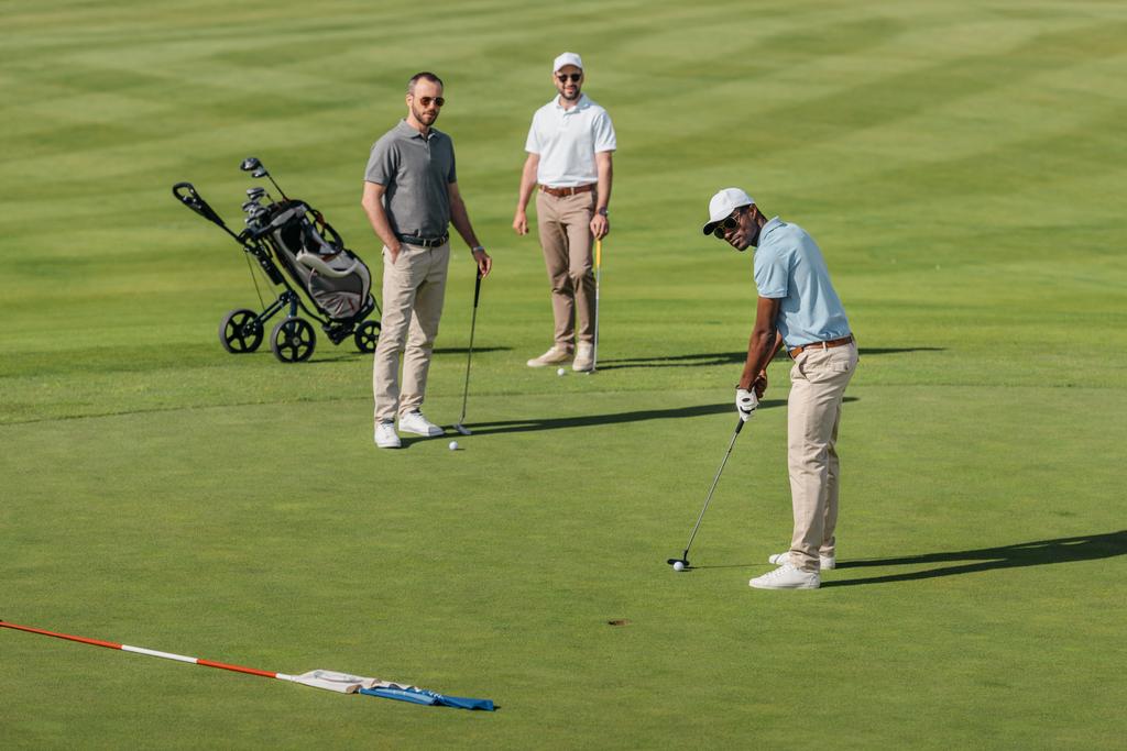 golfista afroamericano tomar un tiro
 - Foto, Imagen