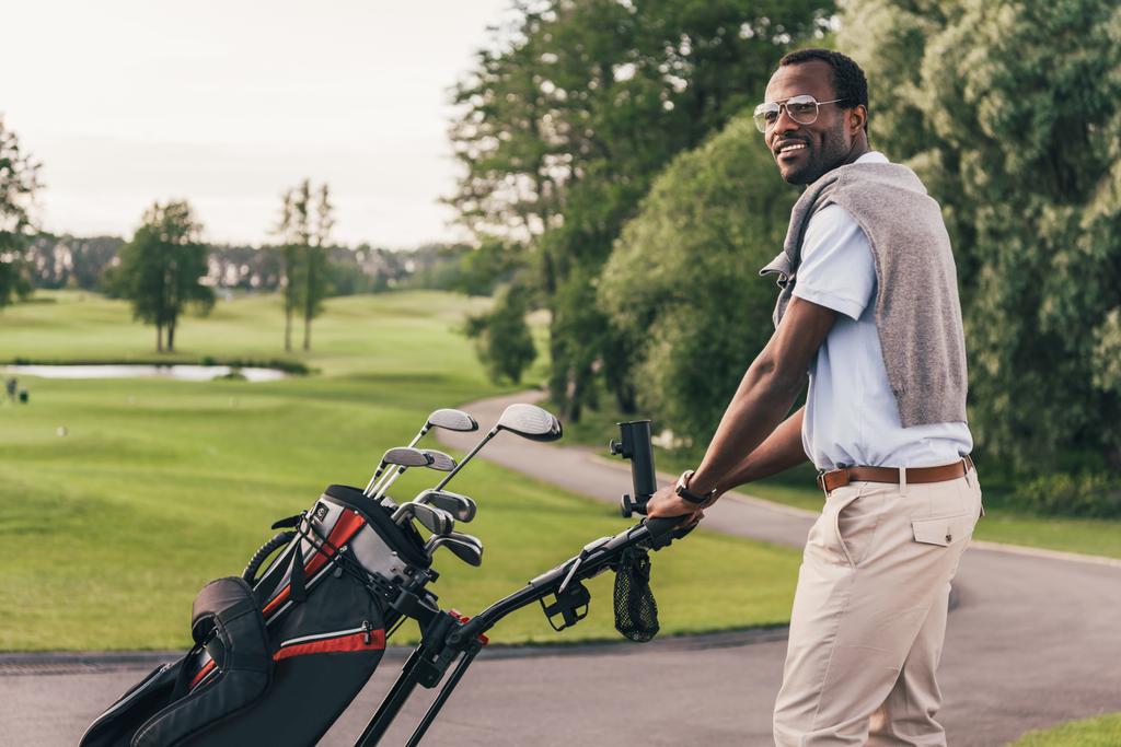 Homem com tacos de golfe no saco
  - Foto, Imagem