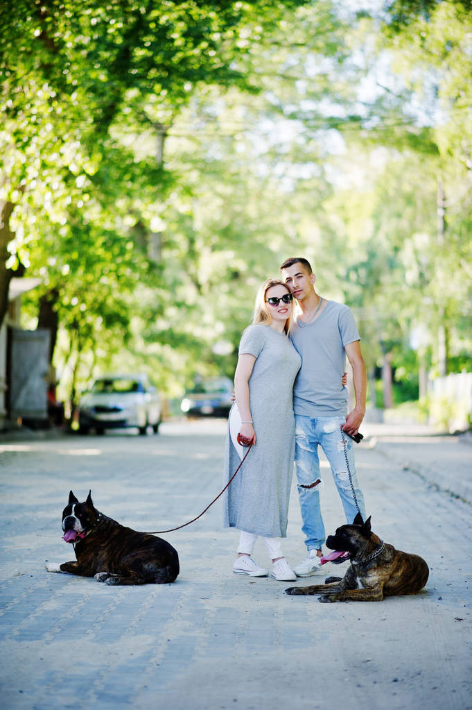 Ζευγάρι στην αγάπη με δύο σκυλιά τεριέ του bull κοιλωμάτων για μια βόλτα. - Φωτογραφία, εικόνα