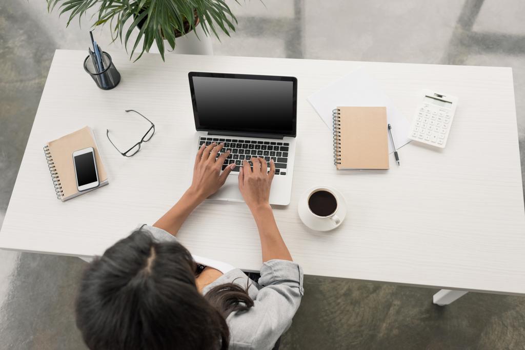 donna d'affari che utilizza il computer portatile mentre seduto sul posto di lavoro
 - Foto, immagini