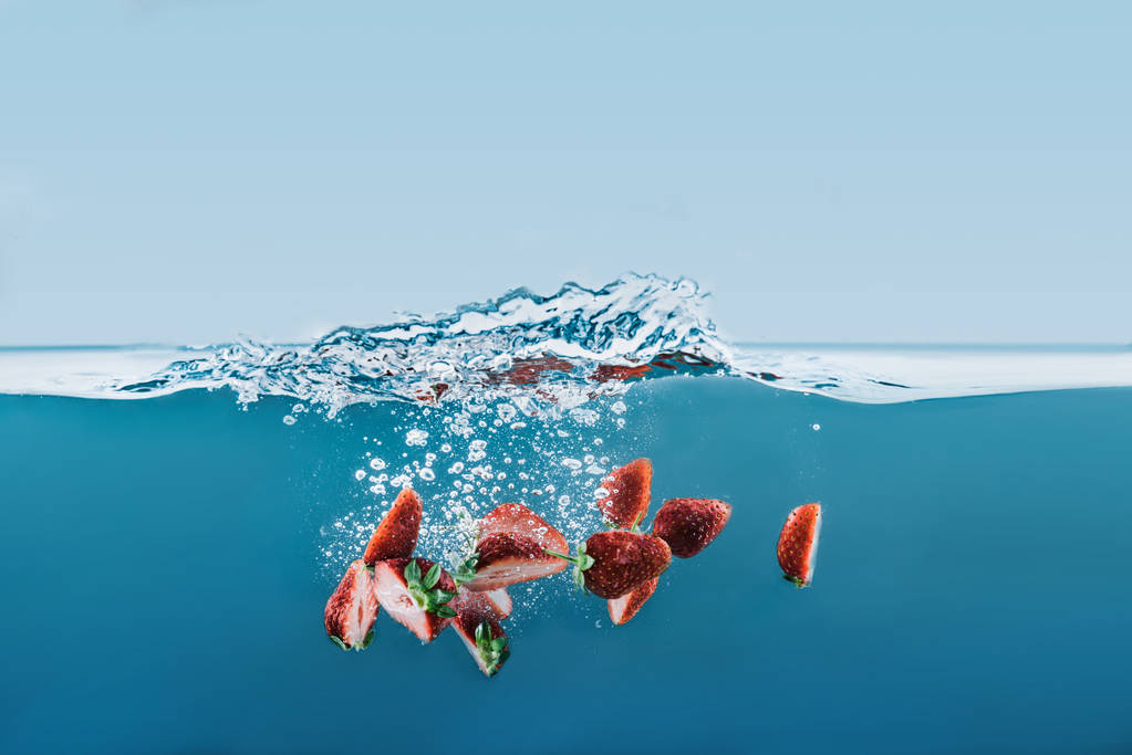 水しぶきと水に落ちるイチゴの部分 - 写真・画像