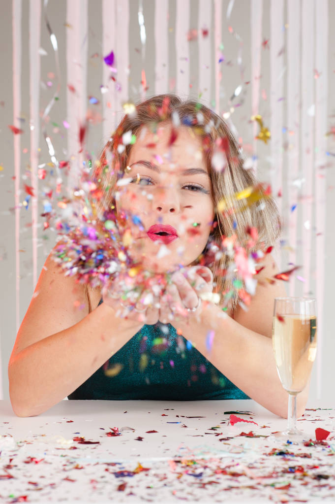 Ragazza felice che soffia brillantini colorati a una festa
 - Foto, immagini