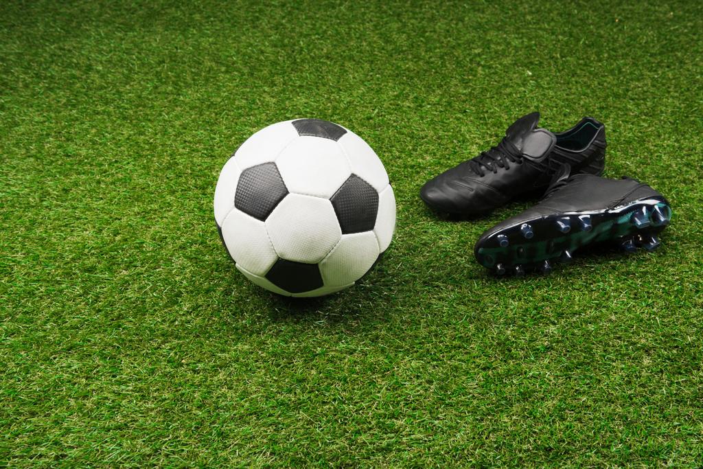 pelota de fútbol con botas negras
 - Foto, imagen