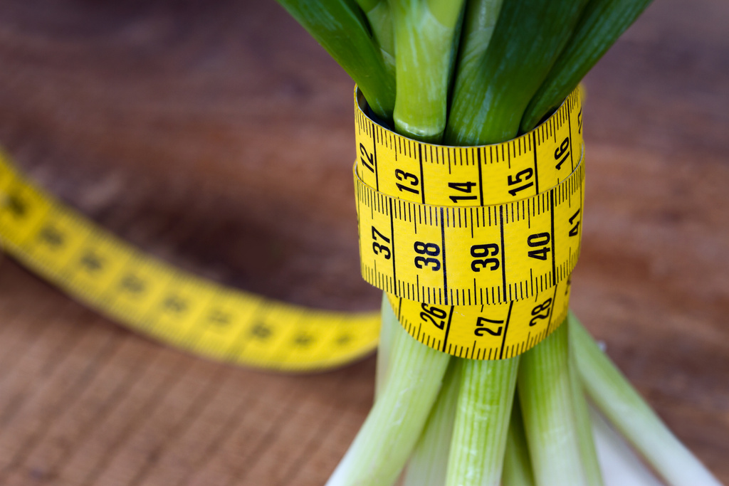 Green onions with yellow measurement tape - Photo, Image
