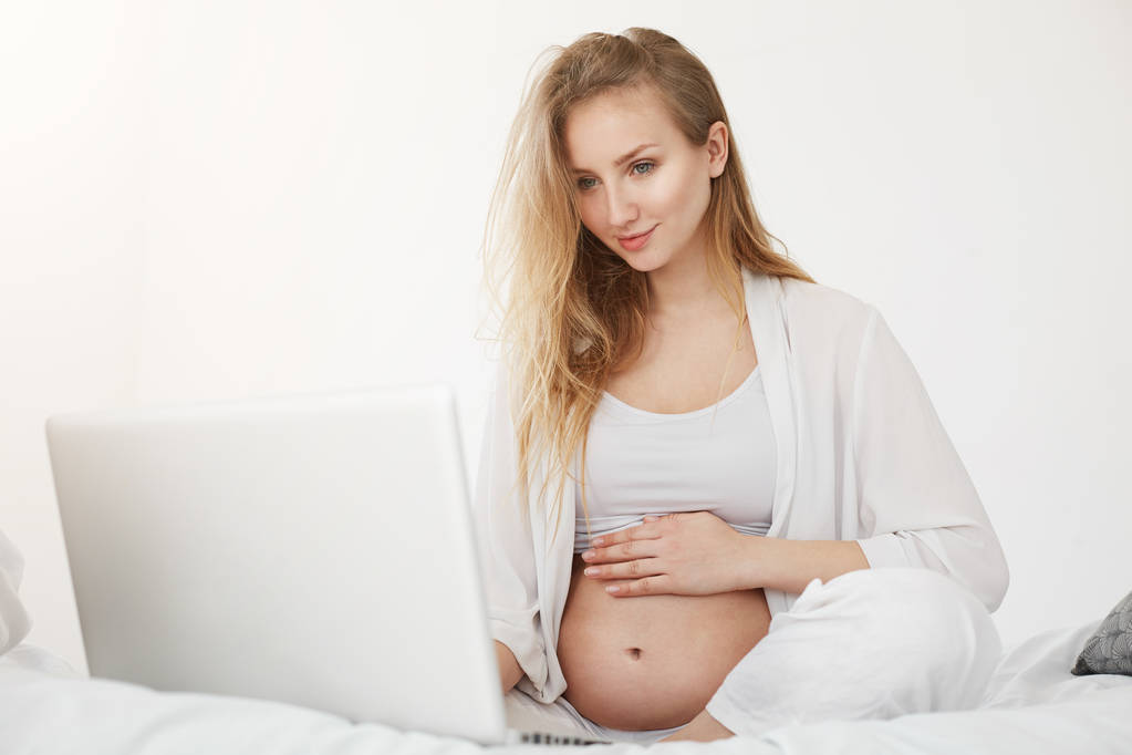 Fiatal terhes üzletasszony online fut a baba ruháit tárolhatja. Anyai vállalkozói szabadúszó otthoni munka. - Fotó, kép