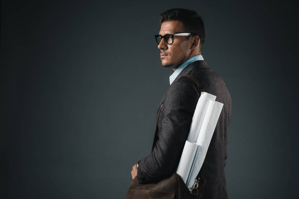 businessman with blueprints in bag looking away - Photo, Image